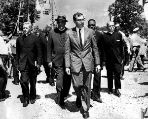 These clergymen of varied faiths head for a patrol wagon at Gwynn Oak Park during yesterday's anti-segregation demonstrations include the Rev. Joseph M. Connolly (left), of the Catholic Interracial Council, the Rev. Dr. Eugene Carson Blake (second from left), stated clerk of the United Presbyterian Church, and the Rev. Marion C. Bascom (fourth from left), pastor of Douglas Memorial Church. More than 250 persons were arrested at the amusement park. Photo by Clarence B. Garrett/1963 file photo