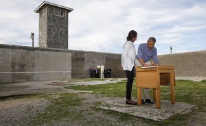 U.S. President Obama writes in a guest book as he tours Robben Island near Cape Town
