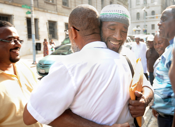Baltimore, Md--7/25/13--Left, Alexander Mustafa embraces (facing camera) Saleem El-Amin outside Courthouse East after El-Amin and several inmates convicted of murder are released. Mustafa, who had been in prison, but has been out for 17 years, met El-Amin while they were incarcerated. The men just released were convicted before 1980 and the Court of Appeals ruled jurors had been given improper instructions. Kim Hairston/The Baltimore Sun--#1841