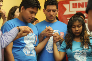 Left to right, praying at the end of a press conference: Jose Dominguez, Edwin Vasquez, Yanderi Hernandez. Representatives from hispanic and African American communities held a press conference at CASA de Maryland regarding ideas to prevent violence between the two communities. (Barbara Haddock Taylor, Baltimore Sun)
