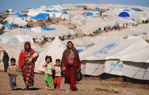 Syrian internally displaced people walk in the Atme camp, along the Turkish border in the northwestern Syrian province of Idlib, on March 19, 2013. The conflict in Syria between rebel forces and pro-government troops has killed at least 70,000 people, and forced more than one million Syrians to seek refuge abroad. AFP PHOTO/BULENT KILIC        (Photo credit should read BULENT KILIC/AFP/Getty Images)