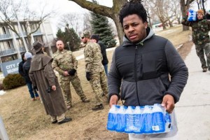 FLINT, MI - JANUARY 24: Darius Simpson, an Eastern Michigan University student from Akron, Ohio, carries water he brought to donate for Flint residents during a rally on January 24, 2016 at Flint City Hall in Flint, Michigan. The event was organized by Genesee County Volunteer Militia to protest corruption they see in government related to the Flint water crisis that resulted in a federal state of emergency. (Photo by Brett Carlsen/Getty Images)